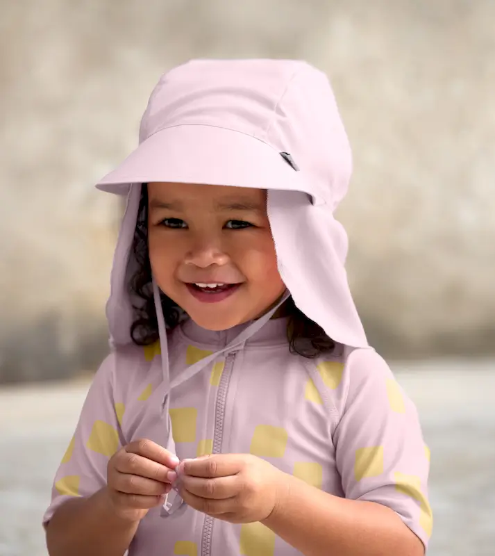 Lächelndes Mädchen in Badekleidung mit rosa Lässig Flap Hat Pale Pink.