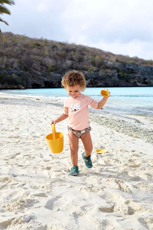 Mädchen mit Schwimmwindel "Wild Cats Choco" von Lässig am Strand