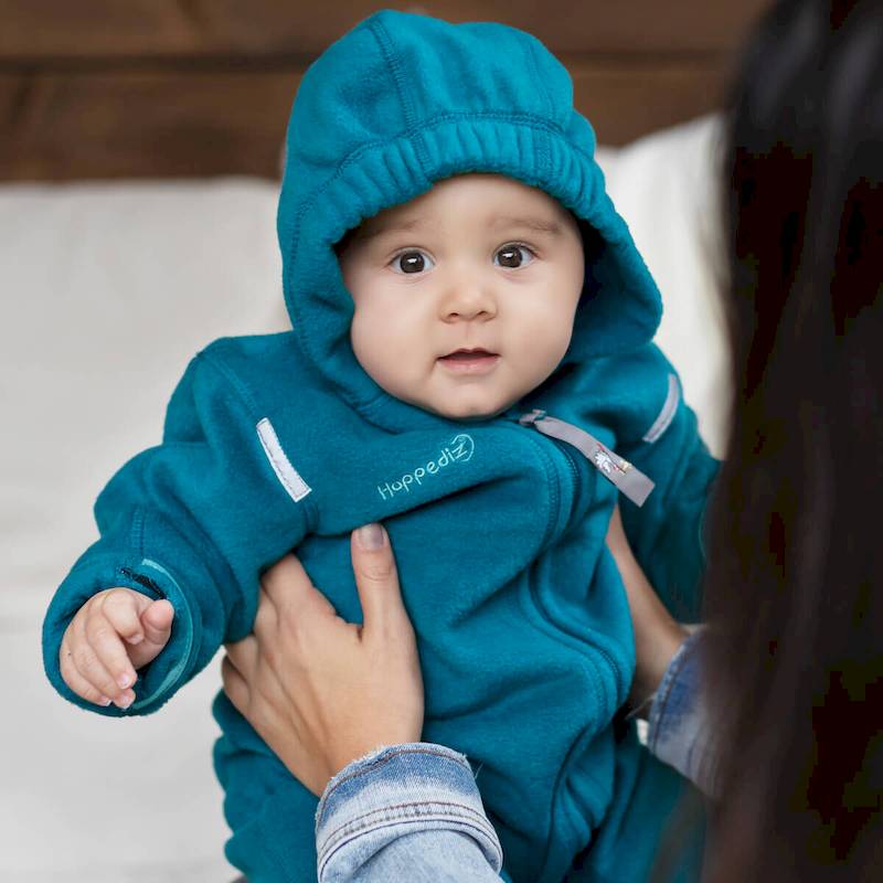 Baby sitzend mit Polarfleece-Overall in Petrol von Hoppediz