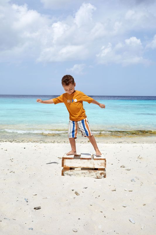 Junge mit UV-Badeshorts Waves Blue Nature am Strand