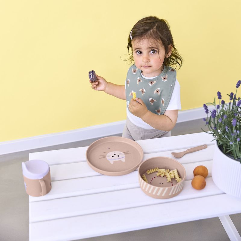 Mädchen an einem Picknicktisch mit dem Kindergeschirrset Tiny Team Cat von LÄSSIG