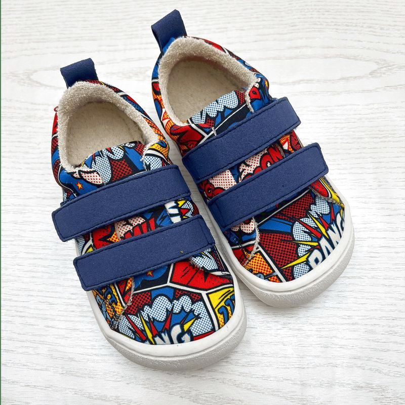 Kinderschuh mit Barfusssohle mit buntem Comic-Print und zwei blauen Klettverschlüssen von oben