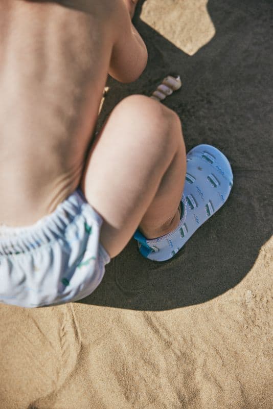 Kind mit Fresk Swim Shoes am Strand