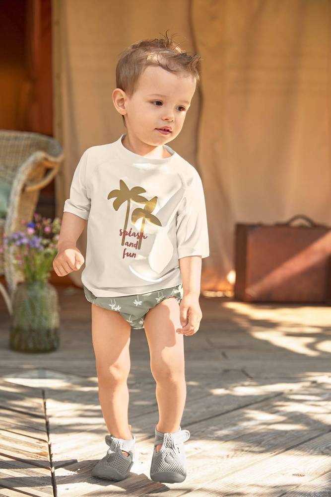 Junge mit LÄSSIG UV-Shirt "Palms Off-White" und Schwimmwindeln "Palms Olive"