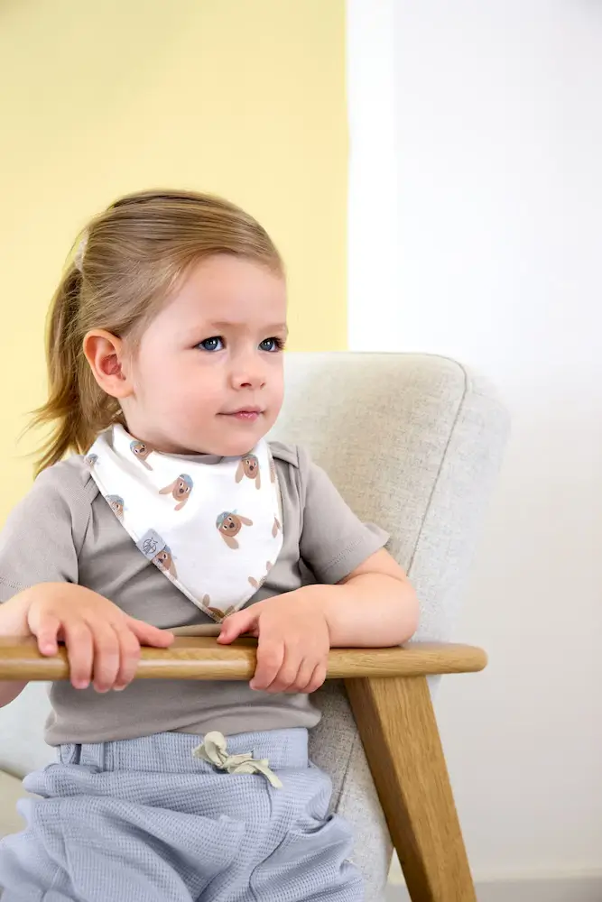 Mädchen trägt Baby Halstuch Tiny Team Dog im Alltag beim Essen und Spielen