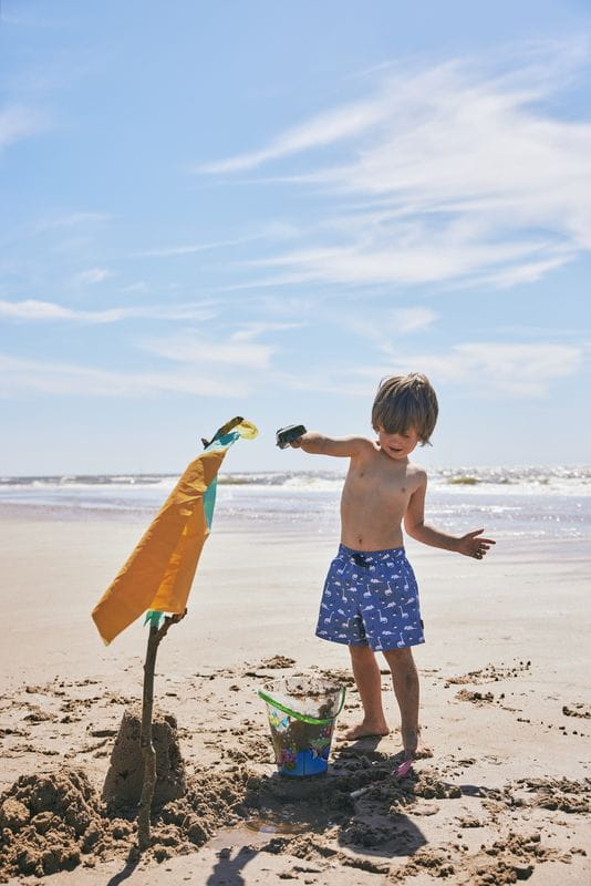 Junge mit FRESK Badehosen "Dino" am Strand