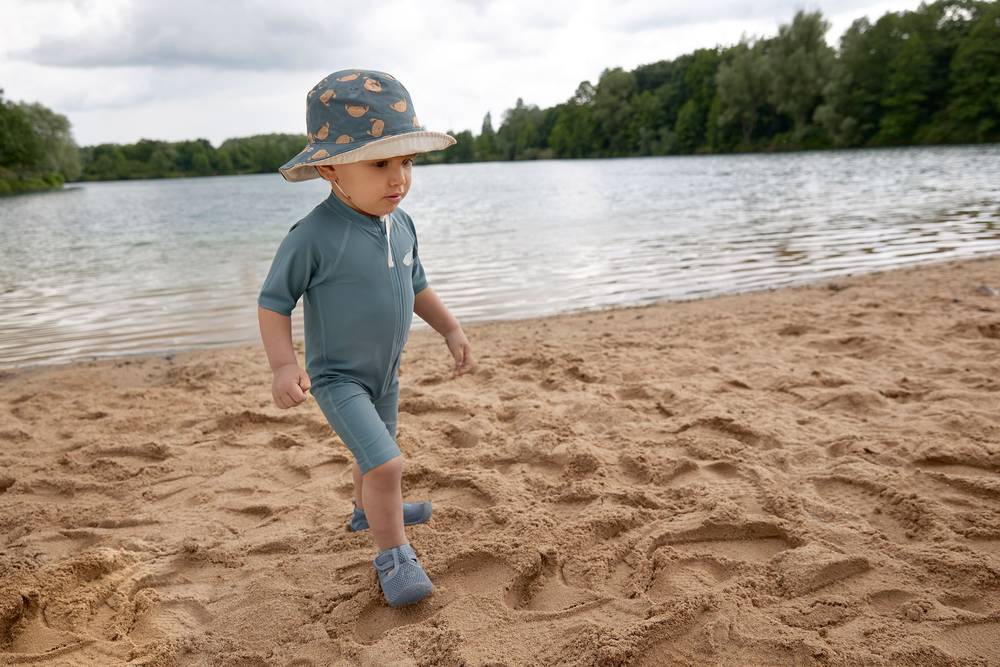 Junge mit LÄSSIG UV Sunsuit "Whale Blue" in Blau