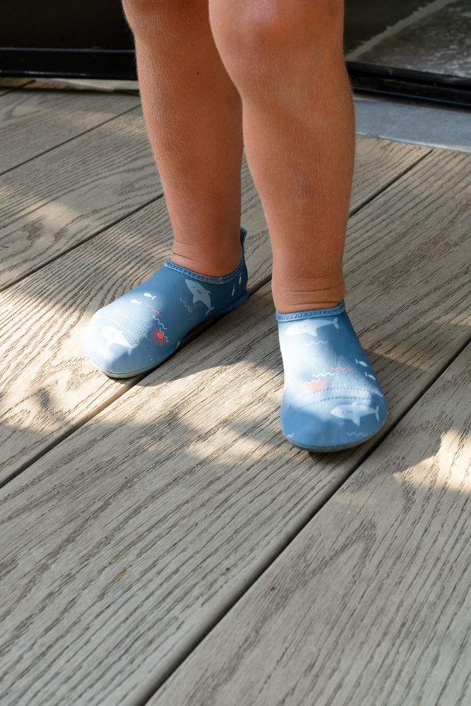 Kind mit den Barfuss-Badeschuhen Shark von Fresk an den Füssen.