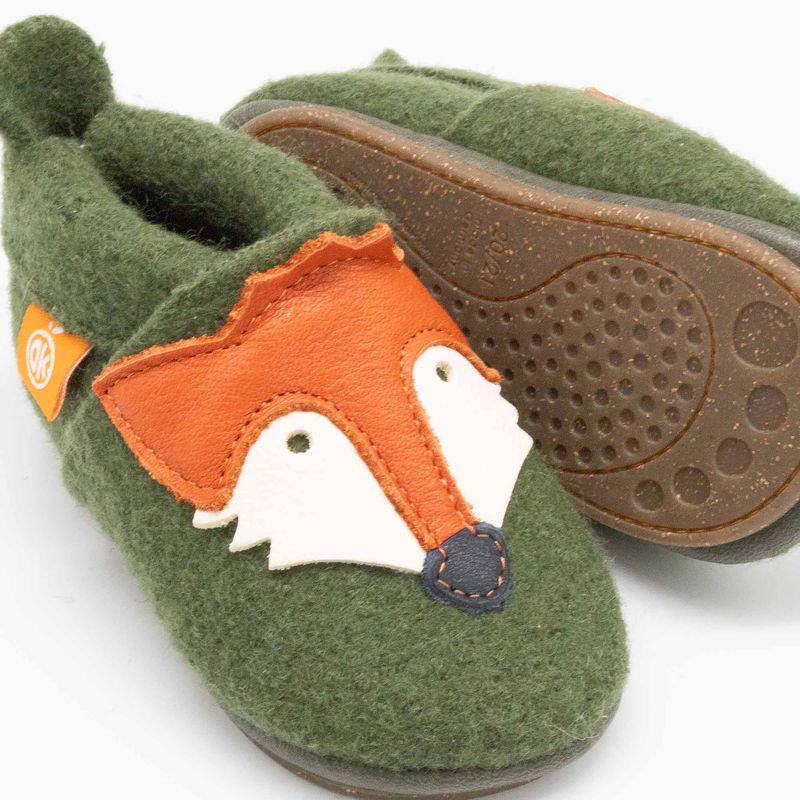 Detailansicht eines grünen Kinderhausschuhs aus Wollwalk mit aufgenähter Fuchsapplikation aus Leder und gummierter Sohle.